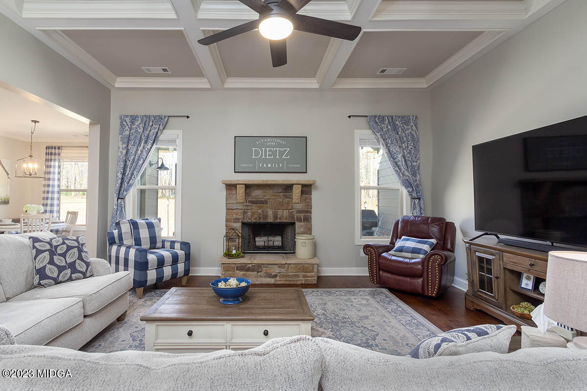 150 Homestead Circle Forsyth, GA 31029 - Photo 9 of 30 a living room with furniture a flat screen tv and a fireplace