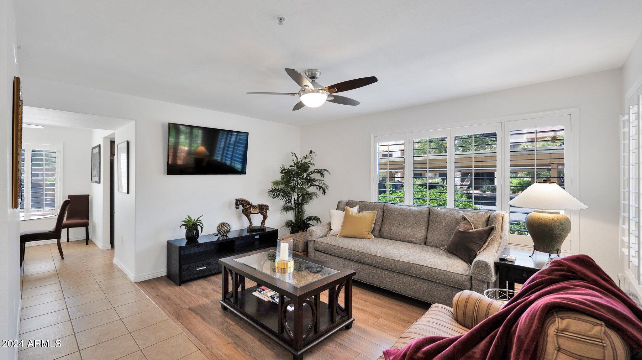 a living room with furniture a flat screen tv and a large window