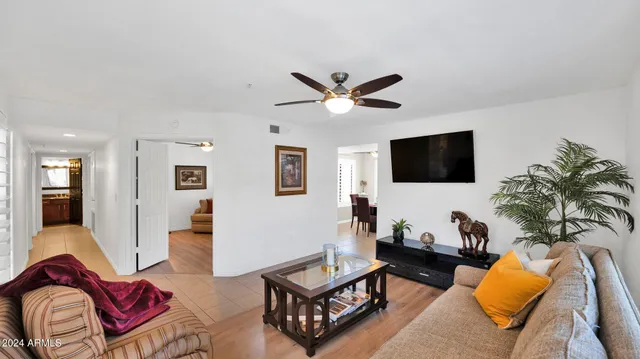 a living room with furniture a flat screen tv and kitchen view