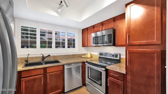a kitchen with stainless steel appliances granite countertop a sink stove and microwave