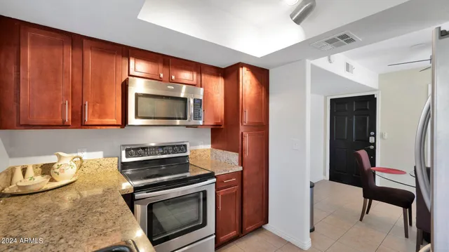 a kitchen with stainless steel appliances granite countertop a stove a microwave and a refrigerator