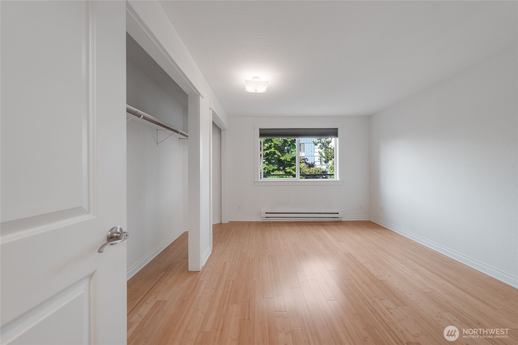 6055 35th Avenue Southwest, Unit 308 Seattle, WA 98126 - Photo 28 of 39 an empty room with wooden floor and windows
