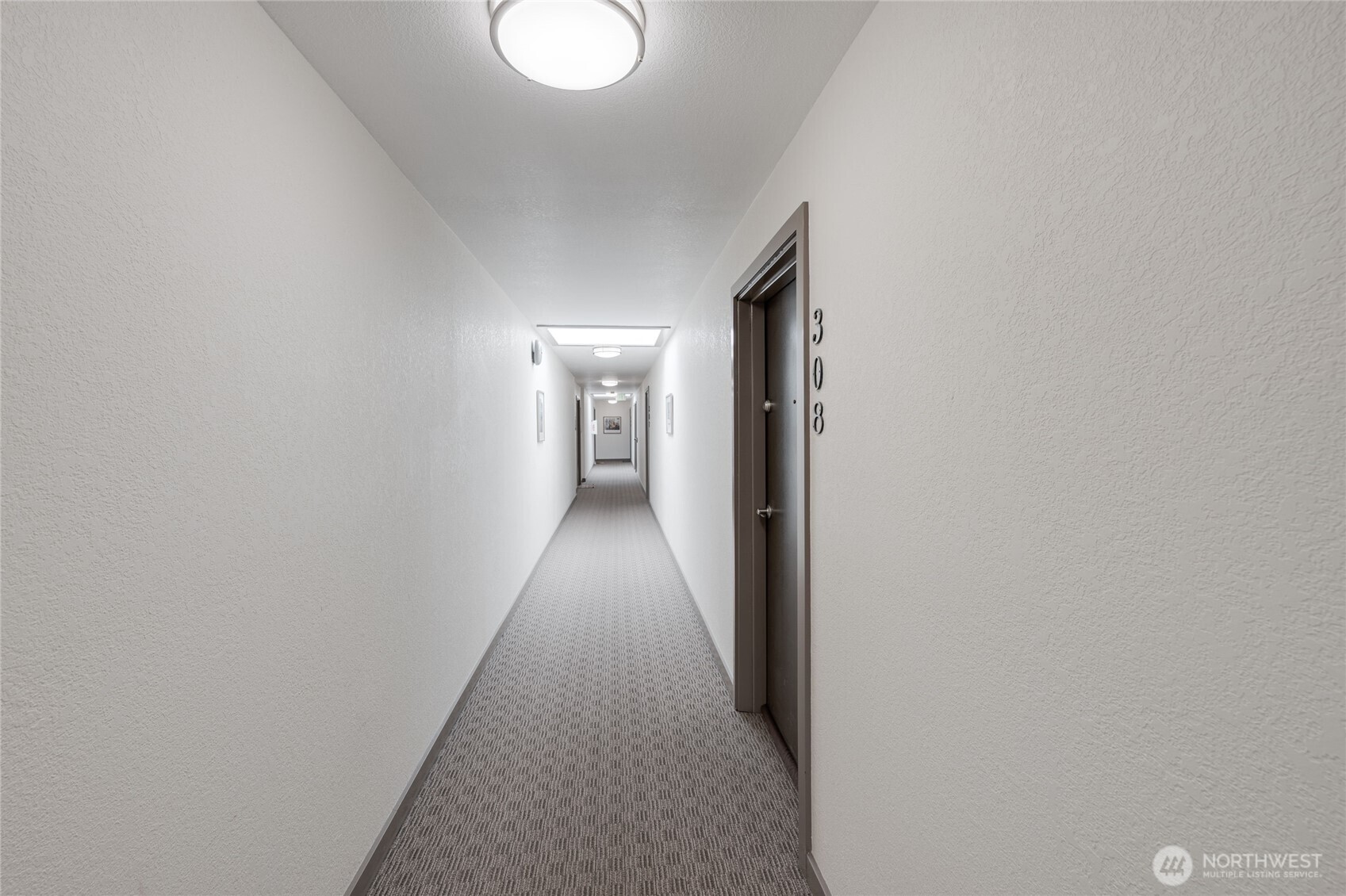 6055 35th Avenue Southwest, Unit 308 Seattle, WA 98126 - Photo 31 of 39 a hallway with wooden floor