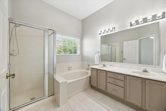 a bathroom with a tub sink shower and mirror