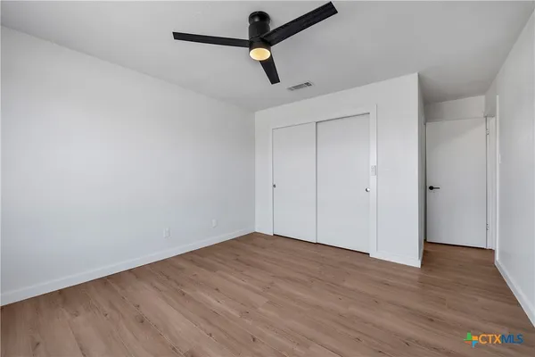 a view of empty room with wooden floor