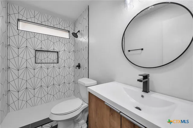 a bathroom with a sink a toilet and a mirror