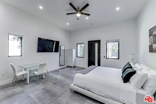 a bedroom with a bed and a flat screen tv