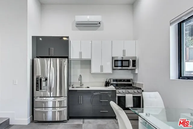 a kitchen with granite countertop a refrigerator stove and microwave