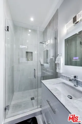 a bathroom with a shower sink and mirror
