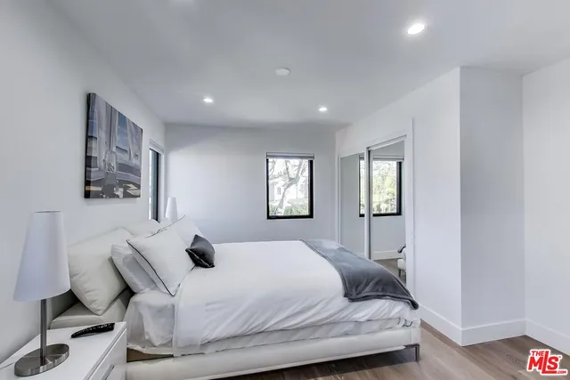 a bedroom with a large bed and a wooden floor