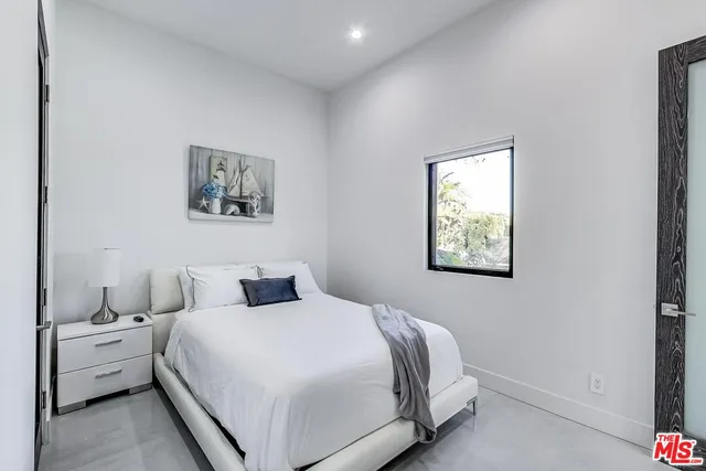 a bedroom with a bed and a painting on the wall