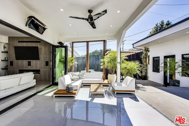 a living room with furniture a flat screen tv and a large window