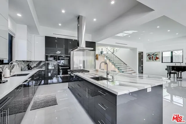 a kitchen with counter top space a sink and living room view