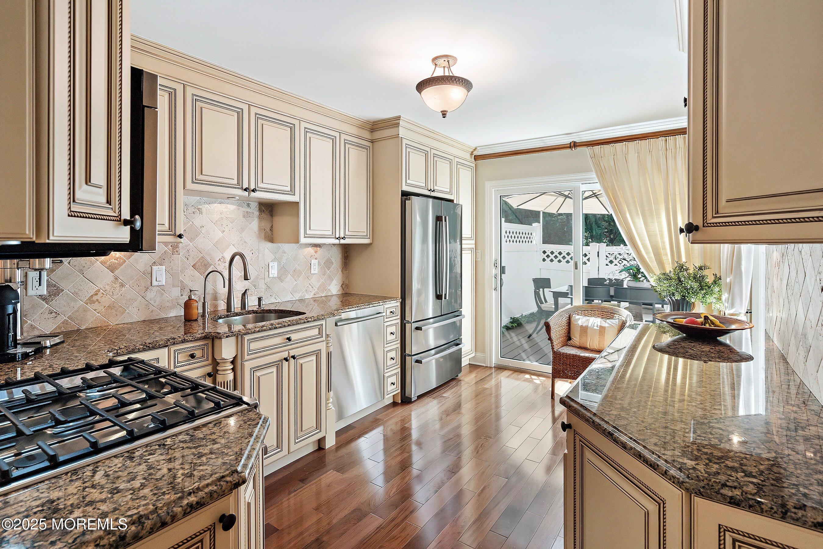 32 Bristel Road, Unit 212 Holmdel, NJ 07733 - Photo 17 of 61 a kitchen with granite countertop a stove a sink dishwasher a refrigerator and wooden cabinets with wooden floor