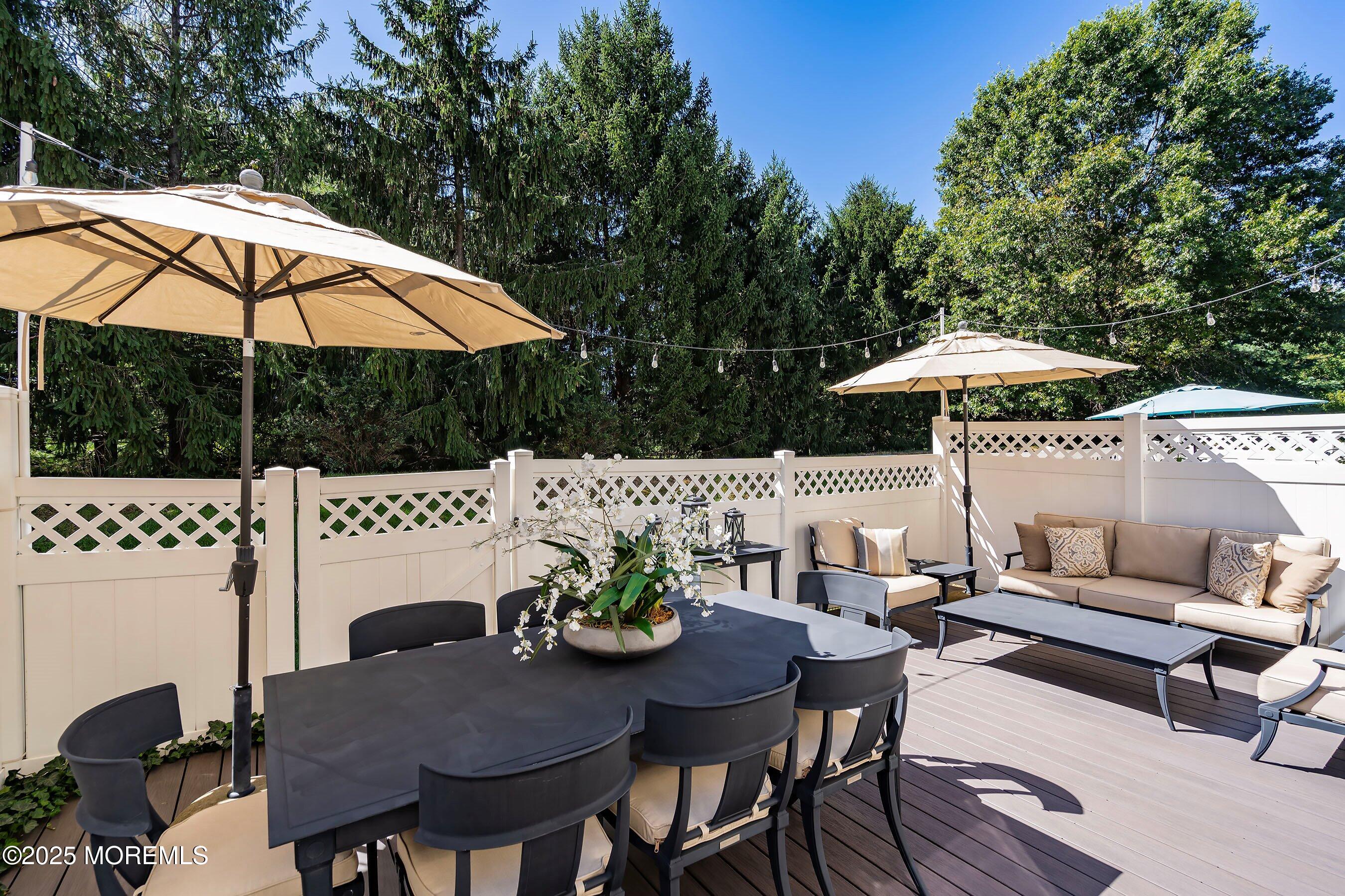 32 Bristel Road, Unit 212 Holmdel, NJ 07733 - Photo 41 of 61 a view of a patio with a dining table and chairs under an umbrella
