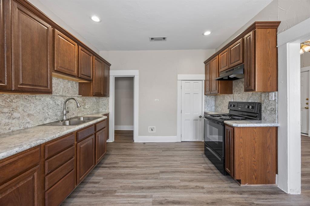 705 Madison Street Cleburne, TX 76033 - Photo 11 of 26 a kitchen with stainless steel appliances granite countertop a stove a sink and a refrigerator