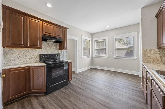 a kitchen with granite countertop wooden floors and stainless steel appliances