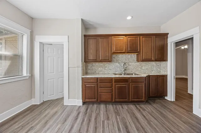 a kitchen with wooden floors and wooden cabinets