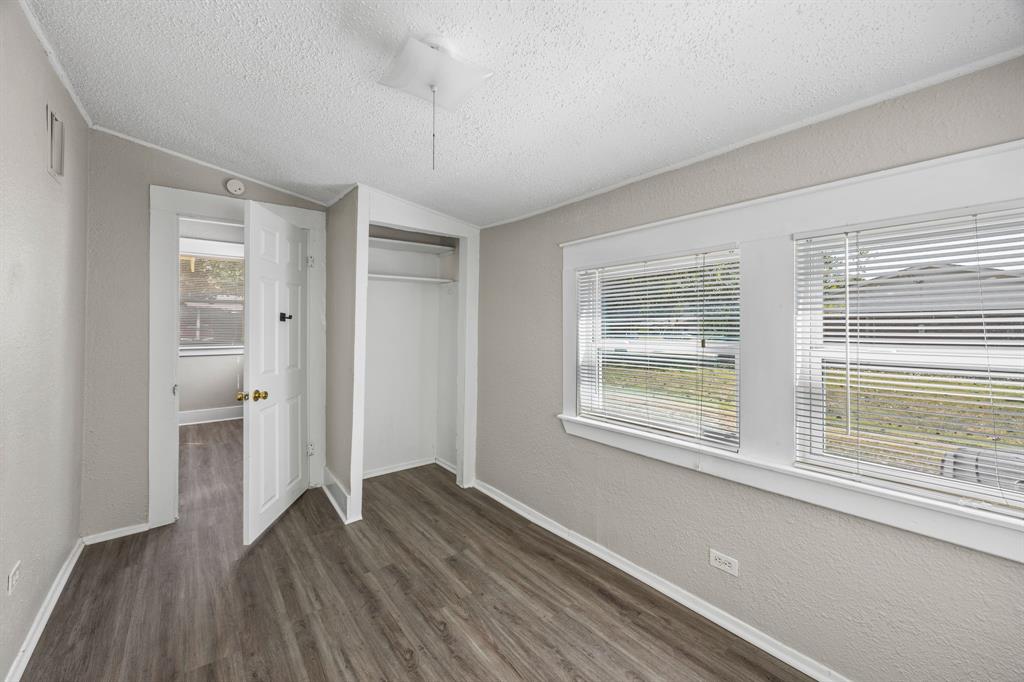 705 Madison Street Cleburne, TX 76033 - Photo 16 of 26 a view of an empty room with wooden floor and a window