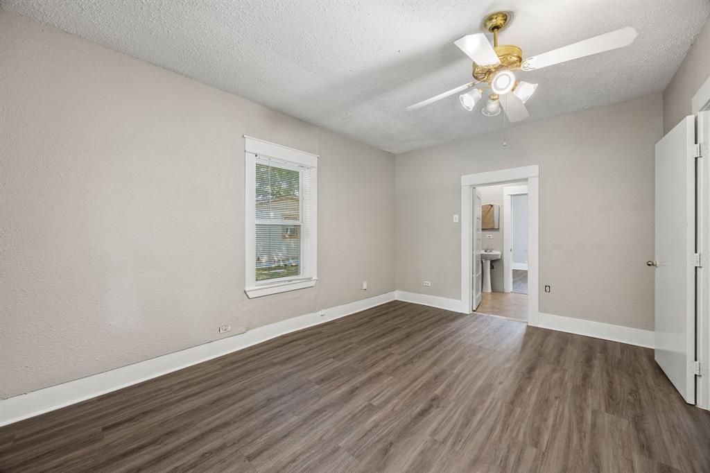 705 Madison Street Cleburne, TX 76033 - Photo 18 of 26 a view of an empty room with wooden floor and a window