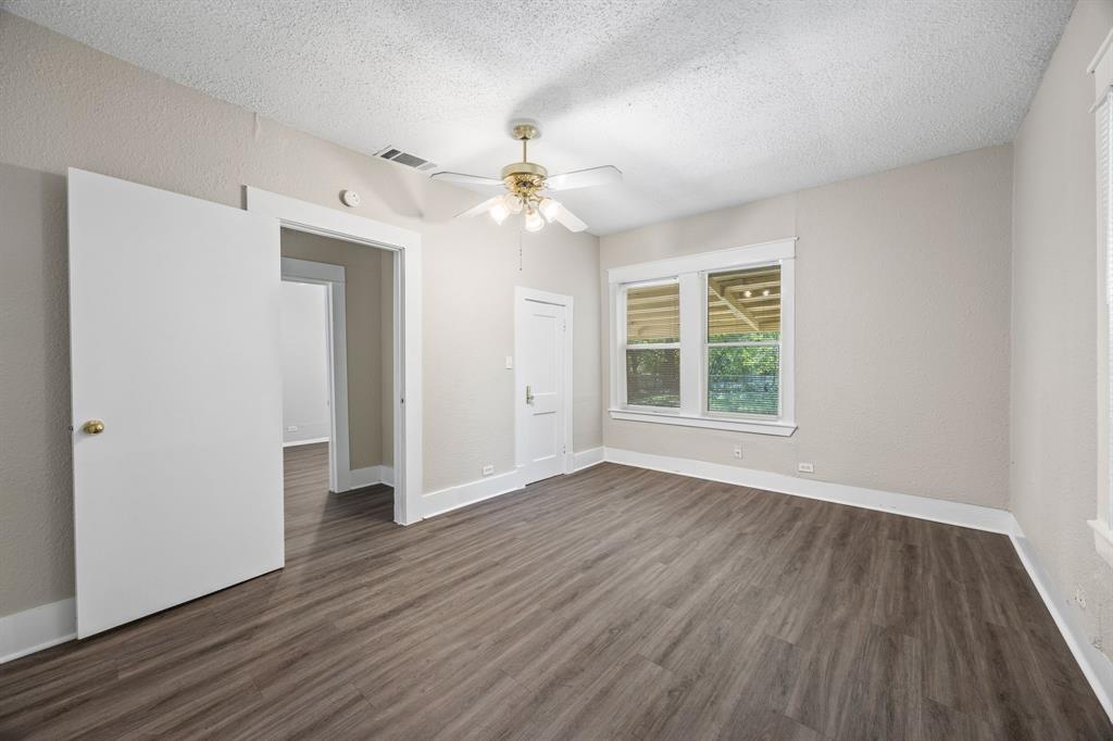 705 Madison Street Cleburne, TX 76033 - Photo 20 of 26 a view of an empty room with wooden floor and a window
