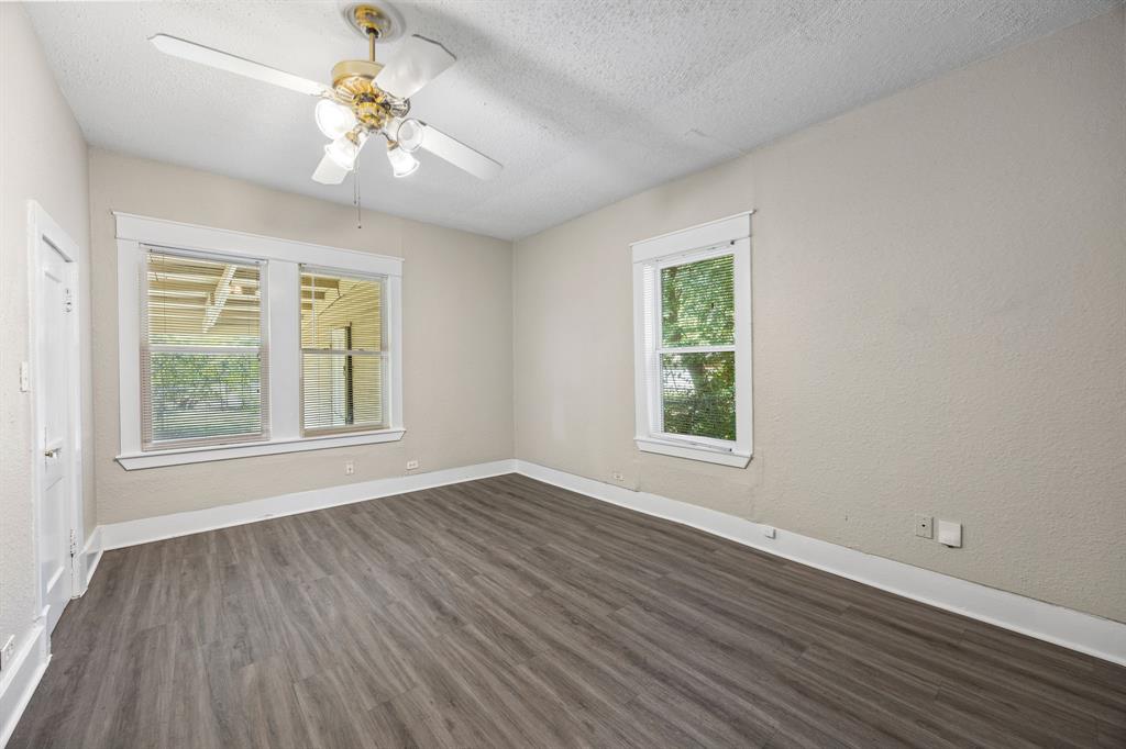 705 Madison Street Cleburne, TX 76033 - Photo 21 of 26 a view of an empty room with wooden floor and a window