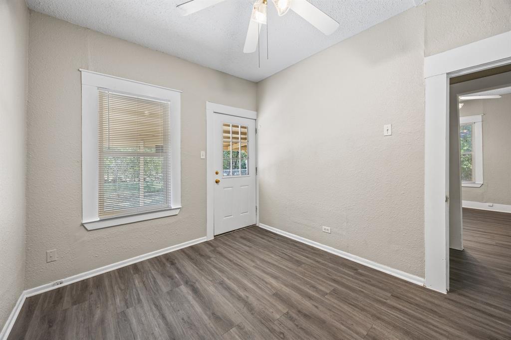 705 Madison Street Cleburne, TX 76033 - Photo 23 of 26 an empty room with wooden floor chandelier and windows