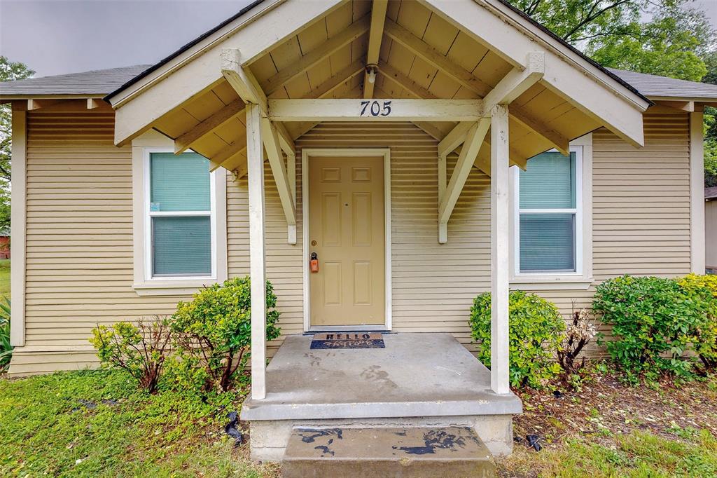 705 Madison Street Cleburne, TX 76033 - Photo 3 of 26 a front view of a house with garden