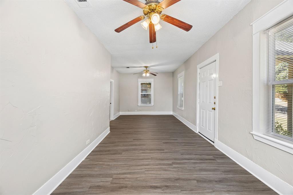 705 Madison Street Cleburne, TX 76033 - Photo 4 of 26 wooden floor in an empty room with a window