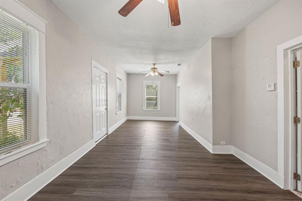 705 Madison Street Cleburne, TX 76033 - Photo 6 of 26 a view of an empty room with wooden floor and window