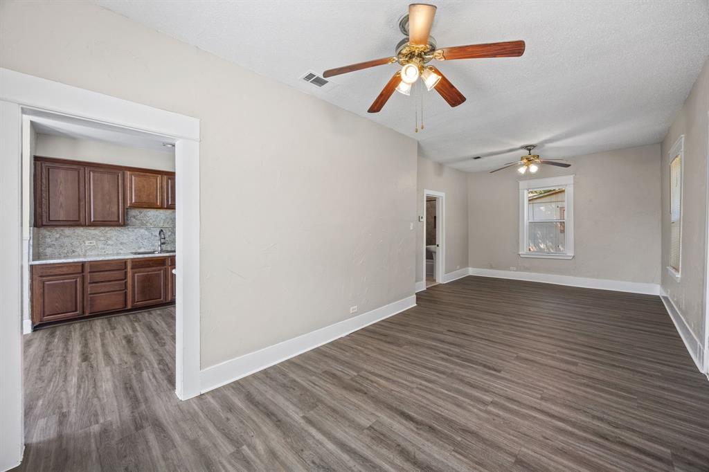 705 Madison Street Cleburne, TX 76033 - Photo 9 of 26 a view of a kitchen a ceiling fan and wooden floor