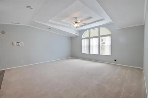 an empty room with windows and ceiling fan