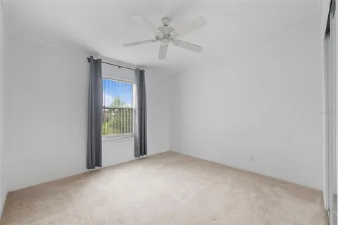 an empty room with a ceiling fan and a window