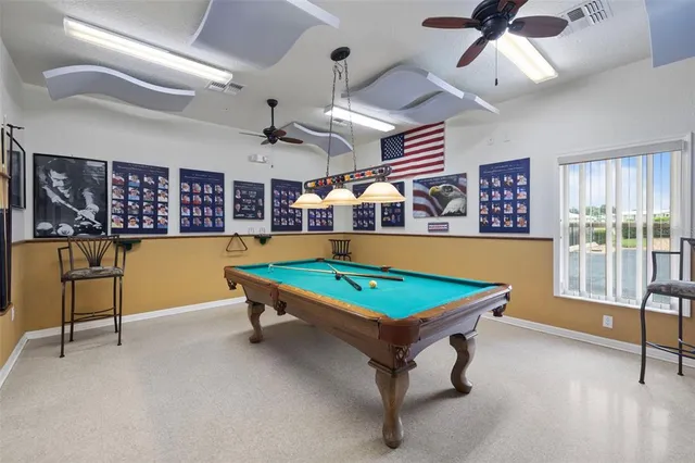 a room with pool table and windows