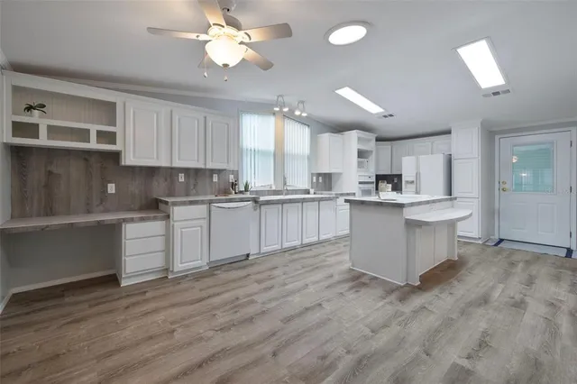 a kitchen with a white cabinets center island and stainless steel appliances