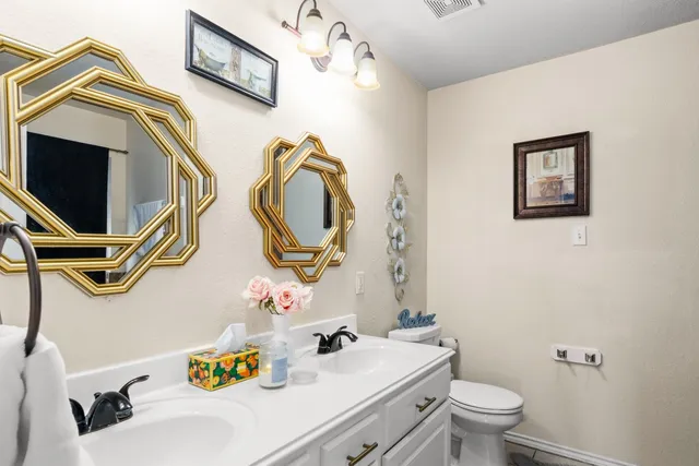 a bathroom with a sink mirror vanity and toilet