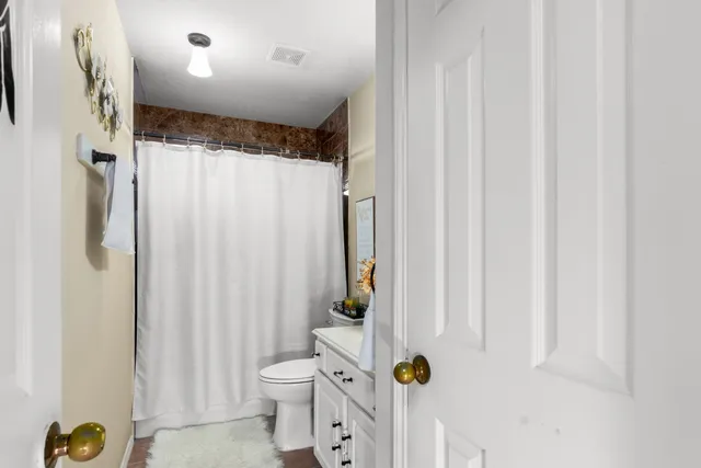 a bathroom with a shower curtain and a toilet