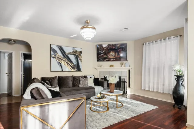 a living room with furniture a flat screen tv and a fireplace