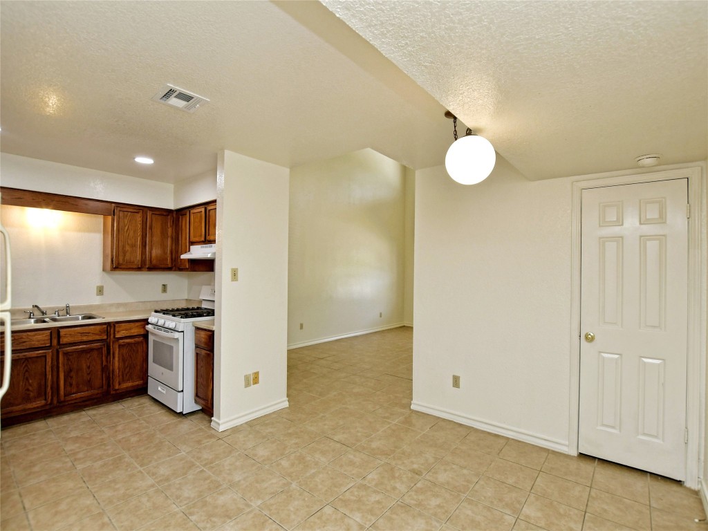 803 Valley View Drive, Unit B Pflugerville, TX 78660 - Photo 8 of 22 a kitchen with stainless steel appliances granite countertop a stove a sink and a refrigerator