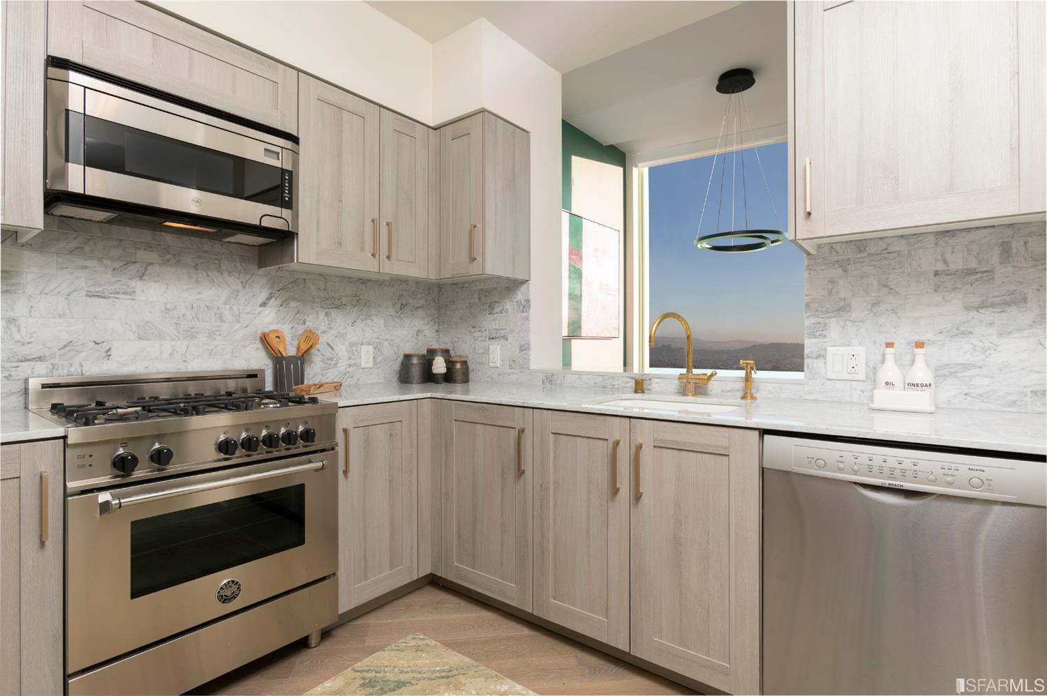 401 Harrison Street, Unit PH49A San Francisco, CA 94105 - Photo 6 of 14 a kitchen with stainless steel appliances granite countertop white cabinets a sink and dishwasher