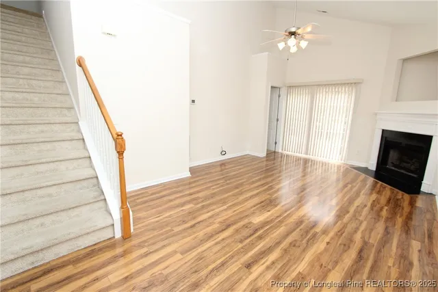 a view of a room with wooden floor and ceiling fan