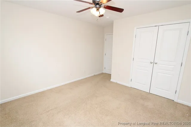 an empty room with a ceiling fan and a window