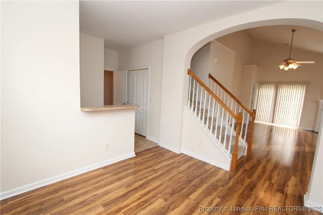 a view of a hallway with wooden floor and staircase