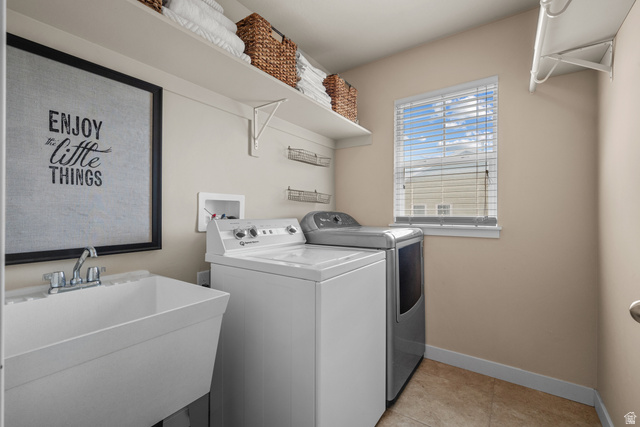 955 Delorean Lane Midvale, UT 84047 - Photo 33 of 47 Dedicated laundry room featuring a utility sink with a chrome faucet, built-in shelving, tiled flooring, and a window for natural light