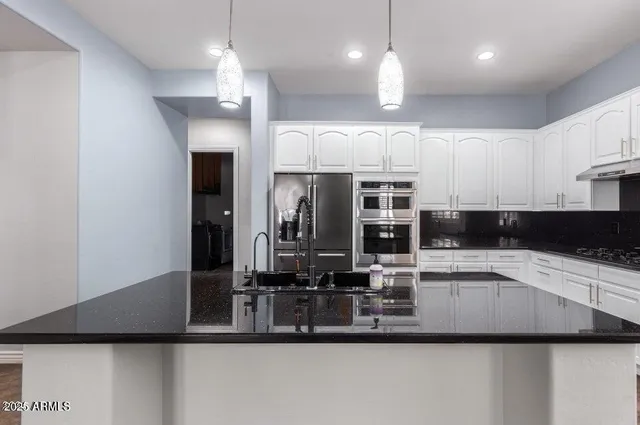 a kitchen with kitchen island granite countertop a sink and refrigerator