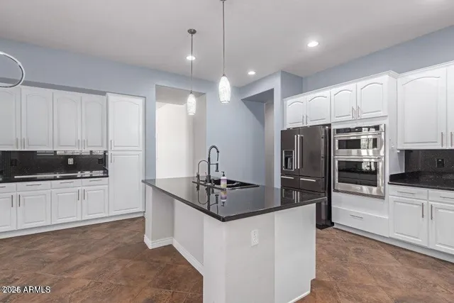 a kitchen with stainless steel appliances a refrigerator sink and stove