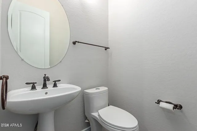 a bathroom with a sink mirror and toilet