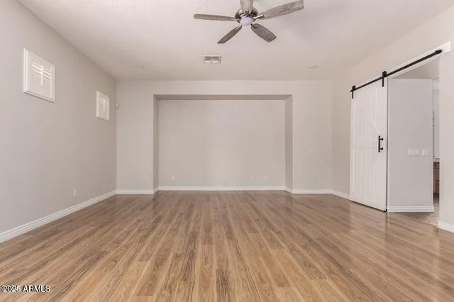 a view of an empty room with wooden floor