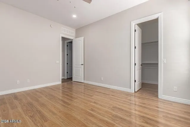 an empty room with wooden floor and closet