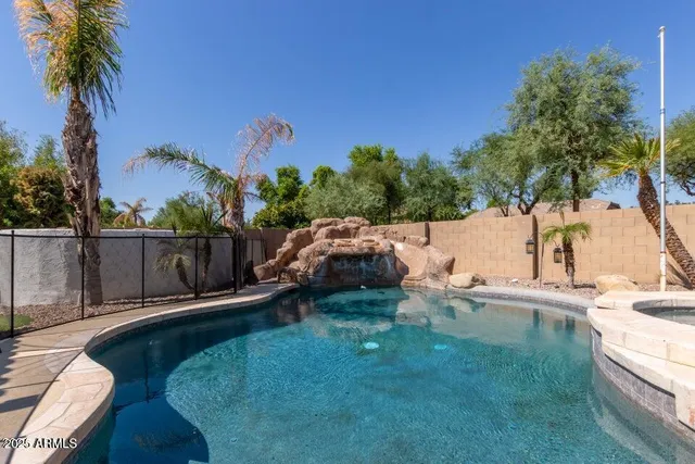a backyard of a house with table and chairs potted plants and palm tree